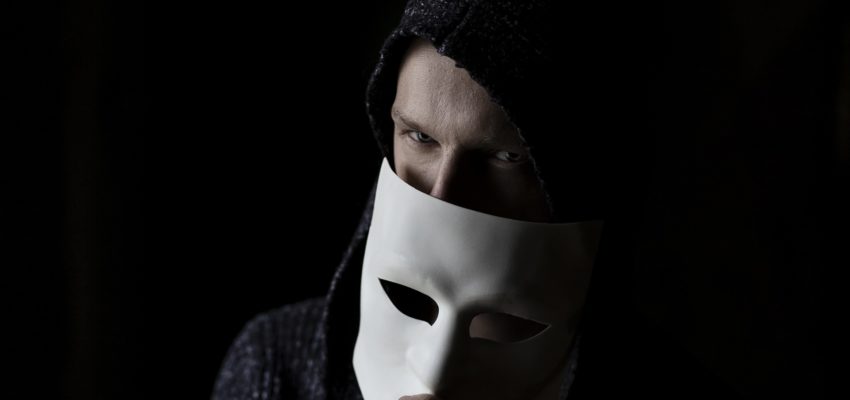 Mann, der sich unter einer Maske versteckt